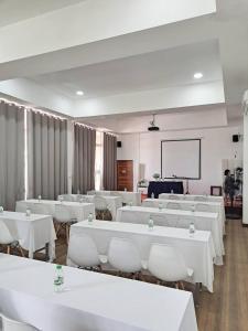 a room with white tables and chairs and a screen at ภูฝ้ายวิลล่า Phufai villa in Chiang Khan +82 photos