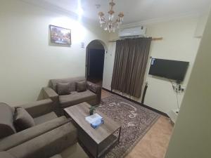 Al Muḩassinにあるالعييري للشقق المخدومة الاحساء 4のソファとテーブルのあるリビングルーム +3枚の写真
