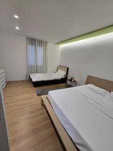 a hotel room with two beds and a window at Neva's Hostel in Librazhd +18 photos
