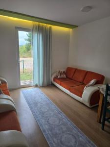 a living room with a couch and a window at Neva's Hostel in Librazhd