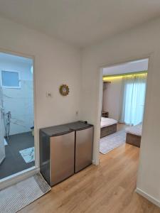 a room with a mirror and a bedroom with a bed at Neva's Hostel in Librazhd