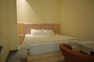 a bedroom with a large bed with white sheets and pillows at Shree shyam hotel & restaurant in Mahendragarh +7 photos