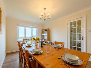 a dining room with a wooden table and chairs at Seaglass House in Beadnell