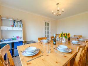 a dining room with a wooden table with chairs at Seaglass House in Beadnell