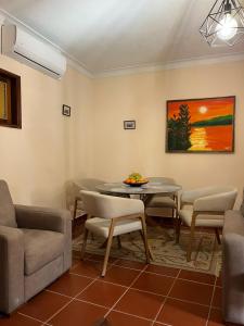 a living room with a table and chairs and a painting at Casa da Avó Ilda in Miranda do Douro