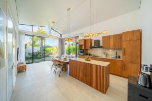 Una cocina y un comedor con mesa y sillas. en Oasis Pandawa 6A - Sun, Sand and Serenity - 3BR Villa with Private Pool, en Ungasan