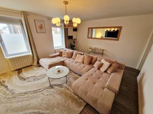 a living room with a large couch and a table at Beautiful High-End Duplex 2 Bedrooms in Hautmont +8 photos