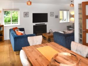 Una sala de estar con un sofá azul y una mesa. en Bracken Lea, en Barbrook