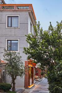 a gray building with trees in front of it at 泉州三品-岚厝 Lan Inn Old Town Center Quanzhou in Quanzhou