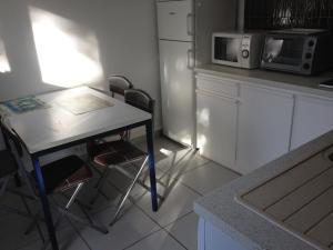 a small kitchen with a table and a microwave at Monta in Montalivet-les-Bains