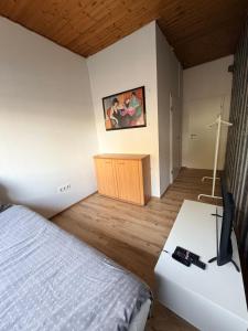 a bedroom with a bed and a desk with a television at Riva Single Apartment in Hamm +2 photos