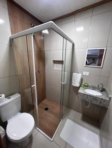 a bathroom with a shower and a toilet and a sink at Pousada Do Siri in Ilha do Mel