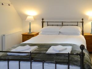 a bedroom with a large bed with two towels on it at The Fish House in Rispond