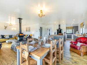 comedor y sala de estar con mesa y chimenea en Towford Farm Bungalow, en Jedburgh