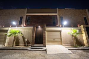 una casa con dos palmeras delante de ella en فلل بكمباوند خاص, en Riad