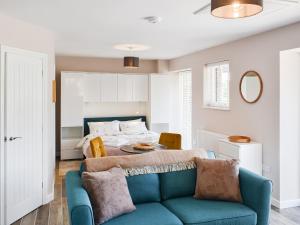 een woonkamer met een blauwe bank en een bed bij Oak - Uk50462 in Alvington