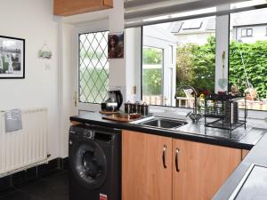 a kitchen with a sink and a washing machine at Riversong in Rhyl