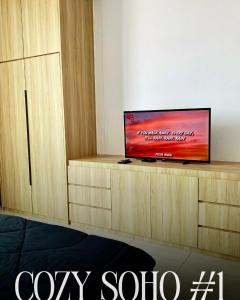 a flat screen tv sitting on top of a wooden entertainment center at Cozy Soho #1 The Stirling Suites by TwoKeys in Miri +6 photos