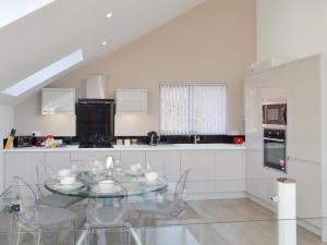 a white kitchen with a glass table and appliances at Waterside Lodge Sixteen - Uk13038 in Southowram +18 photos