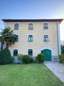 a large house with a green door and a yard at Casa Rural Masión de Egüés in Elcano