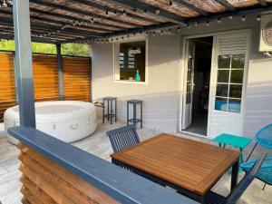 a patio with a tub and a table and chairs at Le belair in Le Diamant