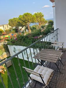 eine Holzbank und Stühle auf einem Balkon in der Unterkunft ThE WHALE HOUSE in El Campello