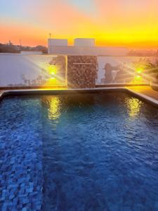 a swimming pool with a sunset in the background at Casa Boituva in Boituva