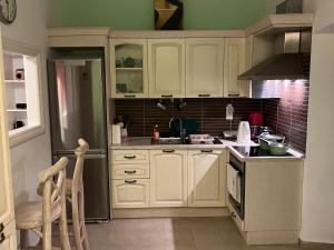 a kitchen with white cabinets and a sink at Nikotsaras beach house since 1930 in Acharavi