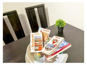 a table with some books on top of it at La MAISON BLANCHE - Ch4A - CENTRAL - CALME - WIFI - White Butterfly Hotels in Dakar