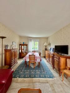 a living room with a table and a tv at Cozy vacation home in Langeais in Langeais