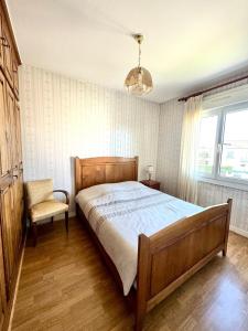 a bedroom with a bed and a chair and a window at Cozy vacation home in Langeais in Langeais