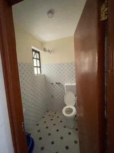 a bathroom with a toilet and a window at Studio Bnb in Kitengela 