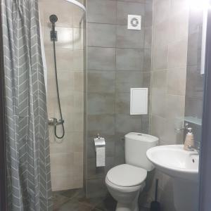 a bathroom with a toilet and a sink and a shower at The White Houses 7 in Nesebar