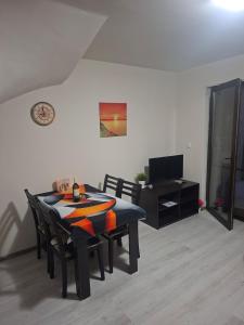 a dining room with a table and chairs and a television at The White Houses 7 in Nesebar
