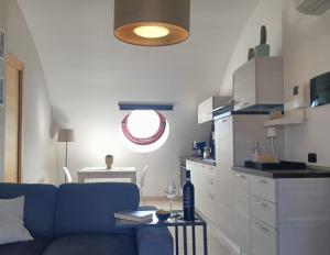 a living room with a blue couch and a kitchen at Casa Tikiri in Casalbordino