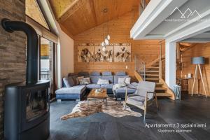 een woonkamer met een bank en een open haard bij Apartamenty nad jeziorem, Czorsztyn - Kluszkowce in Czorsztyn