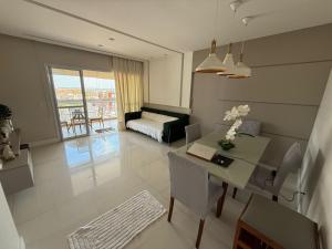 a living room with a table and a couch at Apartamento 03 suítes in Belém