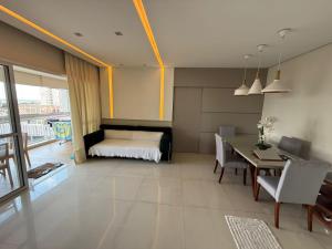 a bedroom with a bed and a table and chairs at Apartamento 03 suítes in Belém
