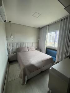 a bedroom with a large bed and a window at Apartamento 03 suítes in Belém