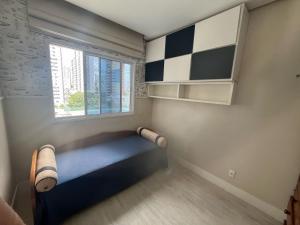 a small room with a bed and a window at Apartamento 03 suítes in Belém
