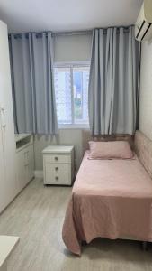 a bedroom with a bed and a dresser and windows at Apartamento 03 suítes in Belém