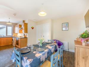 a dining room with a table with blue chairs at Adderstone Folly in Belford