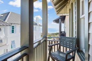 a bench on a balcony with a view of the ocean at Luxurious Four Bedroom Beach Home with Gulf Views in Rosemary Beach +2 photos