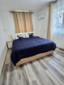 a bedroom with a blue bed and a wooden floor at Le Repos Blue Apartment in Pereybere