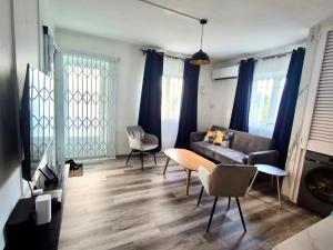 a living room with a couch and a table and chairs at Le Repos Blue Apartment in Pereybere