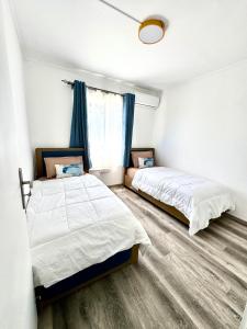 a bedroom with two beds and a window at Le Repos Blue Apartment in Pereybere +3 photos