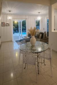 a dining room and living room with a glass table and chairs at Villa Lawrencia in Morne-à-lʼEau
