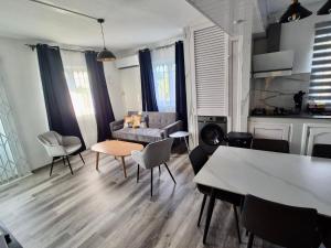 a living room with a couch and a table and chairs at Le Repos Blue Apartment in Pereybere