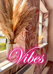 a vase filled with feathers sitting on a window sill at Zeile Zwei - Kloster Zinna in Jüterbog