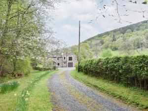 a gravel road leading to a house on a hill at Spring Grove in Pooley Bridge +4 photos